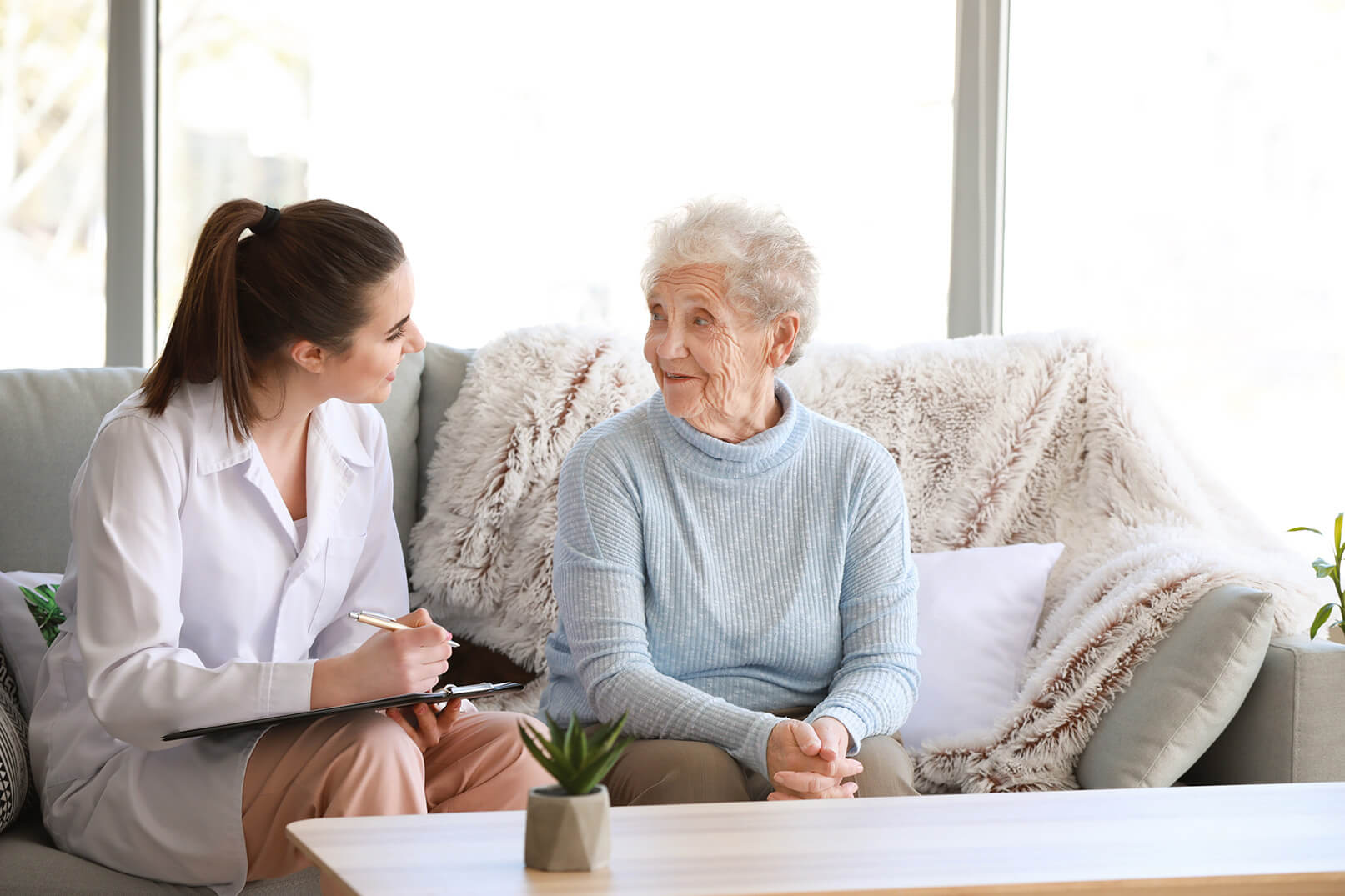 Female doctor receiving information from an older woman patient