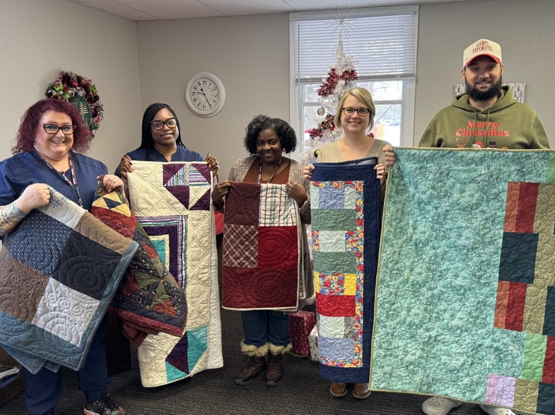 Hospice volunteers with lap quilts for patients
