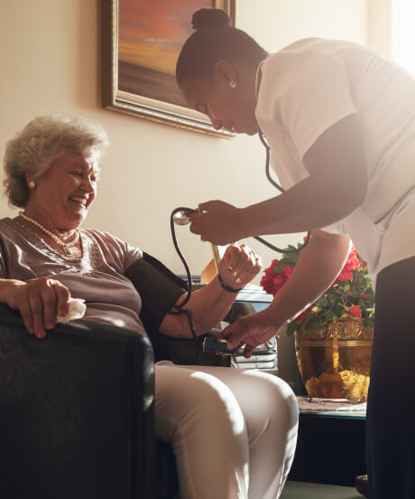 Female nurse performing a blood pressure test on a female patient