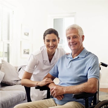 Female nurse with older male patient smiling directly at camera